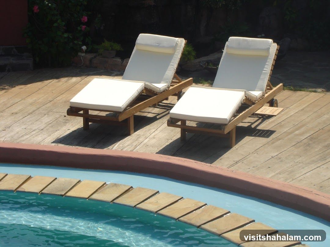 Two lounge chairs by a pool