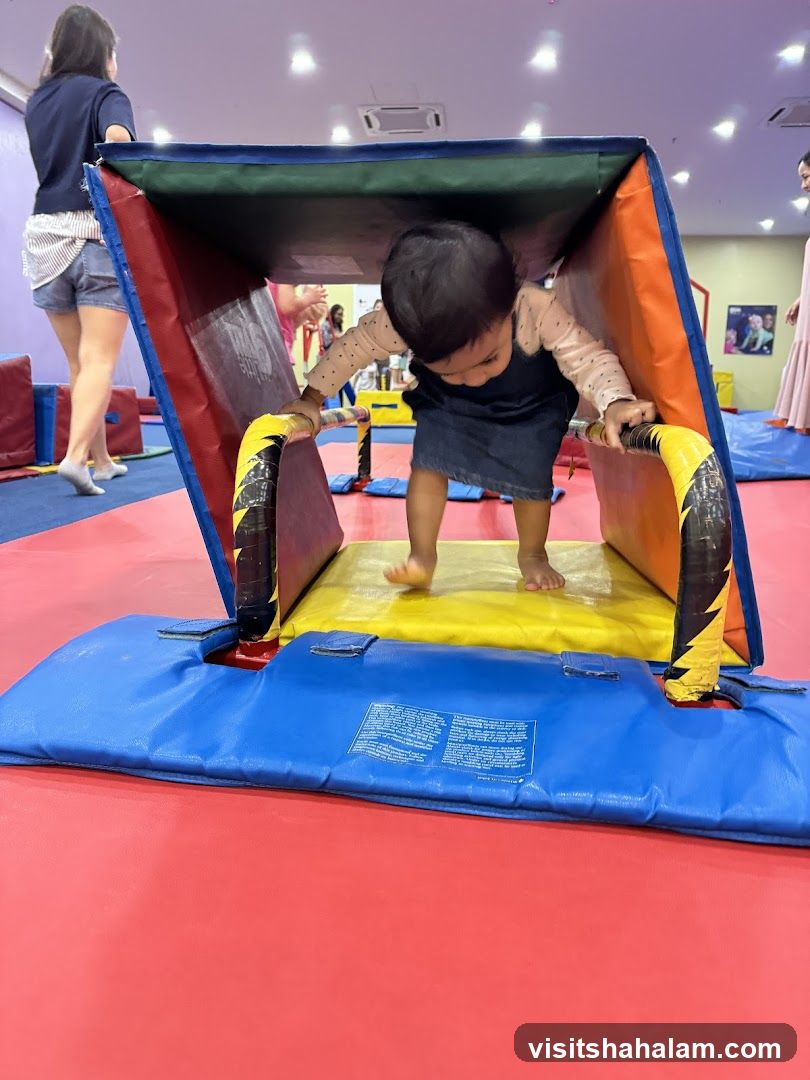 Toddler navigating soft play equipment