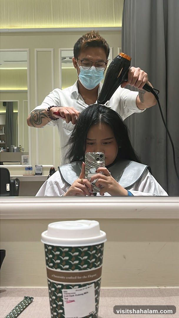 Hairdresser drying client's hair